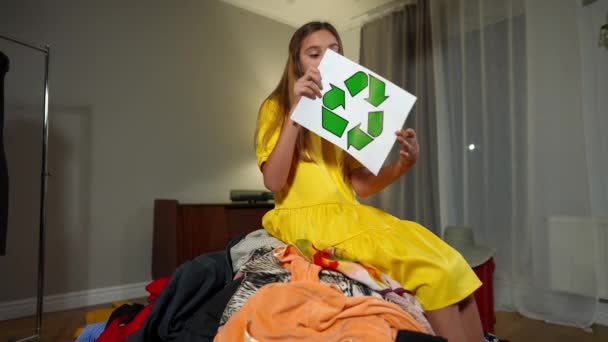 Positief Zelfverzekerd Tienermeisje Met Recycling Symbool Zittend Hoop Kleren Glimlachend — Stockvideo