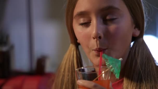 特写微笑的少女喝着玻璃杯里的果汁 带着鸡尾酒伞微笑着握手扇 满意的 轻松的 享受维生素饮料的白人青少年头像 — 图库视频影像
