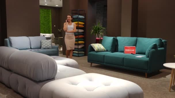 Hermosa Mujer Morena Positiva Caminando Salón Muebles Hablando Por Teléfono — Vídeos de Stock