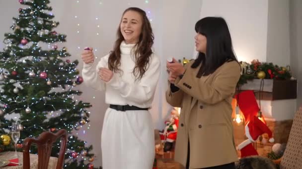 Caucasian Asian Women Blowing Confetti Slow Motion Laughing Standing Indoors — Stock Video