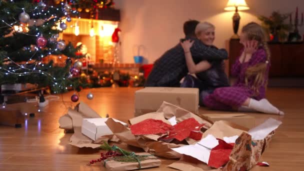 Papel Natal Close Presentes Desembalados Com Abraços Familiares Felizes Borrados — Vídeo de Stock