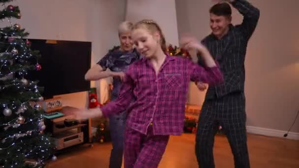 圣诞之夜 在客厅里与父母共舞的快乐少女的画像 除夕之夜 快乐而兴奋的白人女孩 男人和女人在室内玩乐 — 图库视频影像