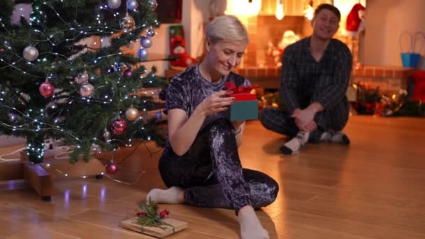 Retrato Mulher Feliz Admirando Presente Natal Com Homem Borrado Sorrindo — Vídeo de Stock