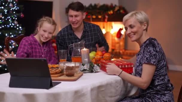 快乐的家人挥手问候亲戚在视频聊天在数码平板电脑上说话的微笑 积极的白人母亲 父亲和未成年女儿在家里庆祝新年前夕网上聊天 — 图库视频影像