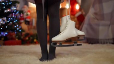 Çıplak ayaklı, siyah külotlu çorap giymiş genç bir kadın. Kapalı bir Noel evinde, yumuşak halıda buz patenleriyle duruyor. Tatil arifesinde yeni yıl hediyesi olan tanınmamış bir genç. Yaşam tarzı ve kutlama