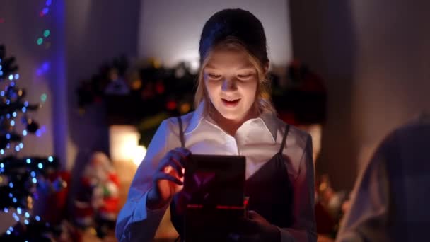 Glada Tonåring Flicka Öppnar Julklapp Med Ljus Inuti Leende Sitter — Stockvideo