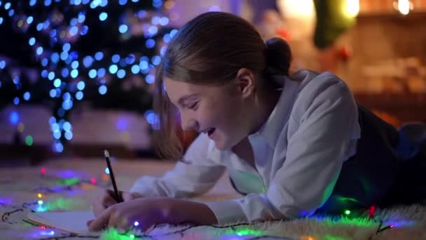 Zelfverzekerde Tienermeisje Schrijven Brief Aan Kerstman Thuis Liggen Oudejaarsavond Glimlachen — Stockvideo
