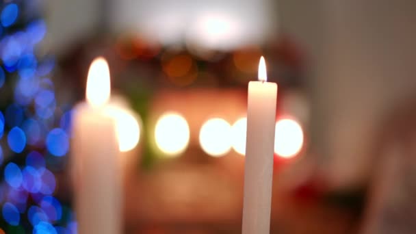 Крупный План Белые Свечи Горят Помещении Рождественскими Огнями Заднем Плане — стоковое видео