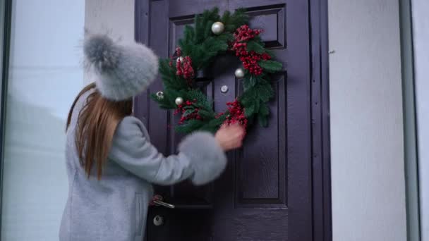 Mujer Joven Entrando Porche Patio Delantero Tocando Corona Navidad Puerta — Vídeos de Stock