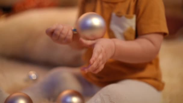 Oigenkännlig Liten Flicka Leker Med Nyårsbollen Sitter Mattan Hemma Inomhus — Stockvideo