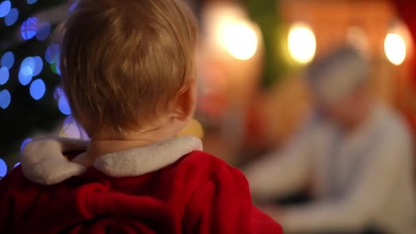 Achteraanzicht Close Curios Kaukasische Baby Rood Kerstman Kostuum Staande Woonkamer — Stockvideo