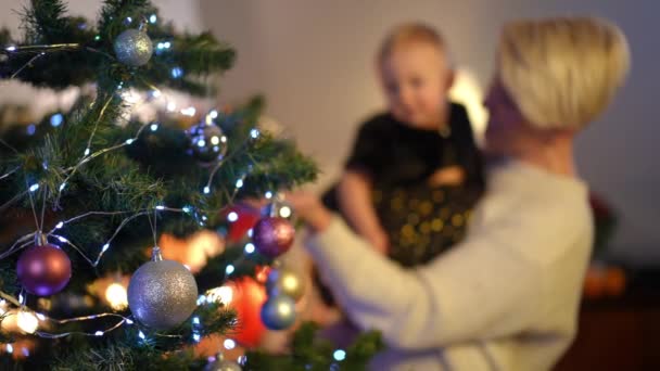 Árvore Natal Close Com Brinquedos Decoração Com Mulher Borrada Bebê — Vídeo de Stock