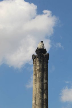 Bulutlu arkaplanı olan Tugu Muda anıtının bir parçası.