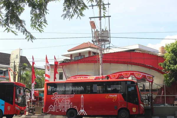 那辆红色的轻型客车在公共汽车候车亭载着乘客 — 图库照片