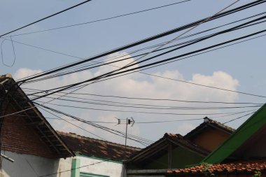 Konutun tepesinden geçen uzun elektrik kabloları