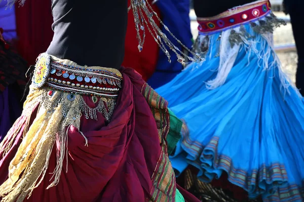 Bright elements of clothing for a gypsy dance, colourful skirts,  a belt with a monist at the waist of dancers