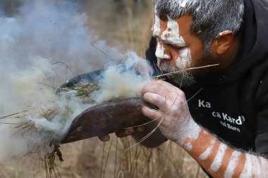 Adelaide, Güney Avustralya - 05-14-2021: Kaurna Kardla Parranthi, Avustralya 'da bir yerel halk etkinliğinde yangın ayini, bir adam okaliptüs dallarından yangın çıkardı