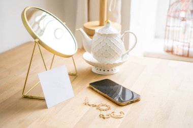 Beyaz bir masanın üzerinde bir fincan kahve, telefon modeli ve Mirrow var. Yüksek kalite fotoğraf