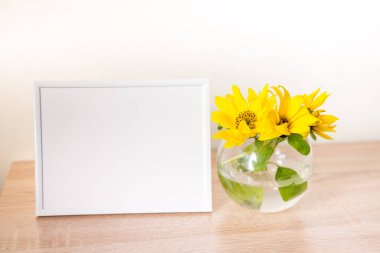 Sarı süsen çiçekli ahşap çerçeve mavi pastel arka planda cam içinde. Yan görüş, kopyalama alanı, model, şablon, bahar, yaz minimalizmi konsepti. Yüksek kalite fotoğraf