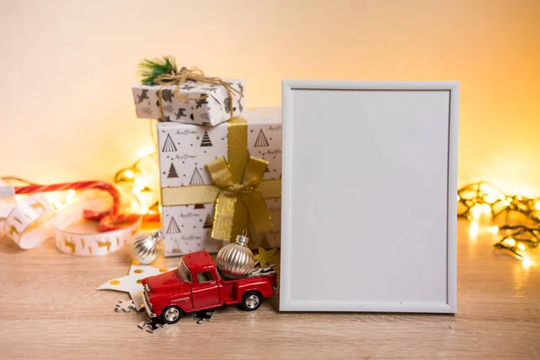 Retrato quadro branco mockup com presentes de Natal, luzes boken — Fotografia de Stock