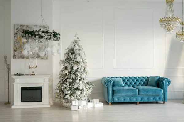 Beautiful holiday decorated room with Christmas tree, fireplace and sofa Cozy winter scene. White interior with lights. High quality photo