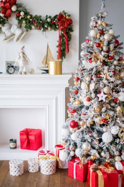 Şömineli oturma odası ve içi moden tarzında hediyelerle dolu Noel ağacı. 