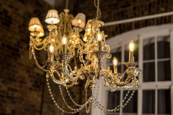 Glass chandelier. Ceiling light source. Lamps shine through a vintage chandelier. High quality photo