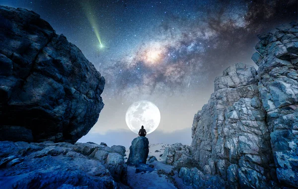 站在岩石上的人晚上在银河和月亮下沉思或祈祷 回头看 — 图库照片