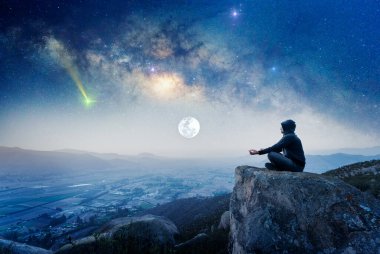Dağda, dışarıda meditasyon yapan ya da geceleri Samanyolu ve Ay 'la dua eden biri.