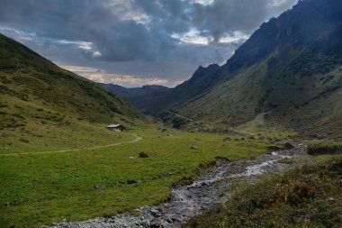 Yaya yolu, dağ deresi ve izole edilmiş bir çiftlik evi olan Idyllic yeşil vadisi, yüksek Alpler 'deki Gargellen, Vorarlberg, Avusturya' nın yukarısında..