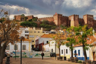 Eski Portekiz 'in Silves kasabası, dev Castelo dos Mouros tarafından yönetiliyor. Ön planda küçük bir kare ve geleneksel evler