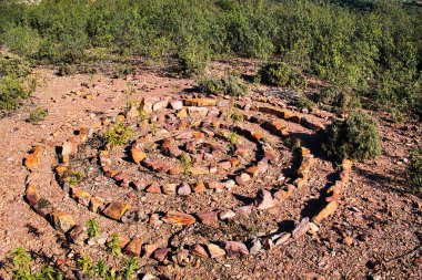 Vale Fuzeiros, Algarve, Portekiz yakınlarındaki kistus kaplı tepelerde, sarmal ve dairesel desenli taşlar serilmiş.