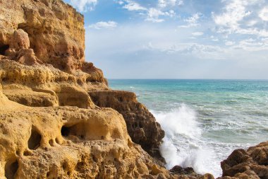 Dalgalar Algar Seco, Carvoeiro, Algarve, Portekiz 'deki kireçtaşı kayalıklarına vuruyor.