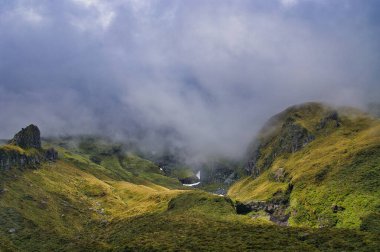 Yeni Zelanda 'daki Taranaki Yanardağı' ndaki (Yeni Zelanda) Humphries Kalesi 'nin engebeli dağ geçitleri ve yarıkları tehditkar bulutlarla örtülüydü.. 