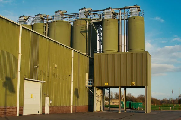 Den Andel, Hollanda, 11-17-2021 sanayi binası, ordu yeşili büyük siloları olan Rixona patates fabrikası Den Andel, Hollanda 'nın Groningen eyaletinde.