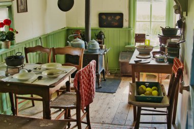 Traditional kitchen in a 19th-century Dutch farmworker's cottage, with a set table, wood stove, pots, pans, kettles and kitchen utensils. Verhildersum, Leens, province of Groningen, Netherlands