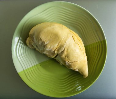 Taze sarı olgun ve yeşil bir tabakta soyulmuş Durian eti. Tropikal meyve, çok kötü kokar.