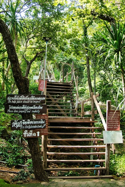 Wooden stairway to the rock temple of Wat Chetiya Wihan Phu Tok (Wat Chetiya Khiri Wihan), province of Bueng Kan, northeastern Thailand, with texts in Thai en Tinglish (Thai English)