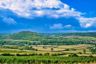 Vzelay Tepesi, Yonne Bölümü, Morvan, Burgundy, Fransa. Küçük çaplı tarım arazileri, ağaçlar ve üzüm bağlarıyla çevrili. Güneşli, yükselen gök gürültülü bulutlarla.