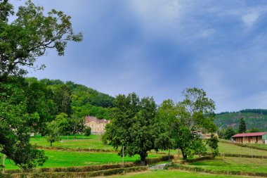 Orman kaplı yamaçlar, çitle kaplı çayırlar ve Fransa 'nın Burgundy, Morvan, Fransa yakınlarındaki Autun kasabasında eski bir malikane.
