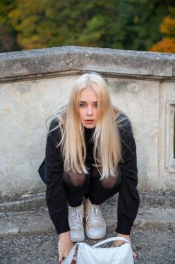 Nehir ve ağaçlarla sonbahar parkında poz veren kız