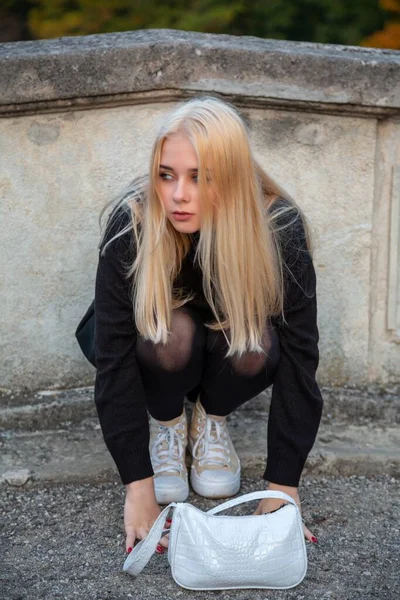 Nehir ve ağaçlarla sonbahar parkında poz veren kız