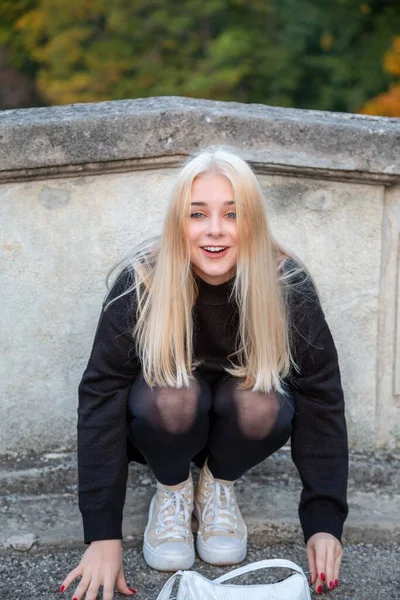 Nehir ve ağaçlarla sonbahar parkında poz veren kız