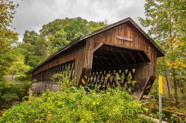 Eyalet Yolu Kapalı Köprü, Ashtabula County, Ohio 'daki Sonbahar Yaprak Renk Değişikliği sırasında Conneaut Creek' in Batı Şubesi 'nden geçer..