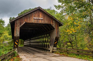 Eyalet Yolu Kapalı Köprü, Ashtabula County, Ohio 'daki Sonbahar Yaprak Renk Değişikliği sırasında Conneaut Creek' in Batı Şubesi 'nden geçer..