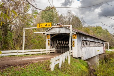 The Root Road Covered Bridge crosses the Ashtabula River during the Autumn leaf color change in Ashtabula County, Ohio.