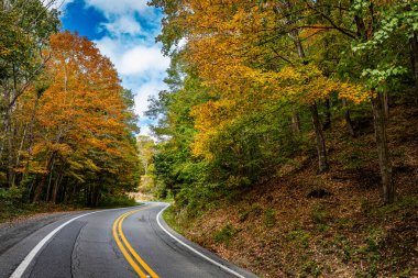 A winding road through the countryside in the Appalachian Mounntain area of West Virginia during the Autumn leaf color change.
