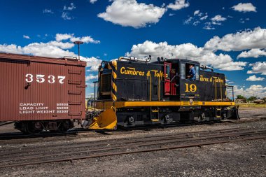 Antonito, CO - 23 Ağustos 2021: Cumbres ve Toltec 19 General Electric 50 ton dizel elektrikli motor lokomotifi Cumbres ve Colorado 'daki Toltec Demiryolu' ndaki kamusal buhar sırasında arka bahçede bir treni destekliyor..