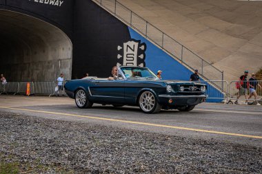 Lebanon, TN - May 14, 2022: Wide angle front corner view of a 1968 Ford Mustang Convertible driving on a road leaving a local car show.