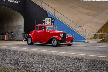 Lebanon, TN - May 14, 2022: Wide angle front corner view of a 1932 Ford 5 Window Coupe driving on a road leaving a local car show.